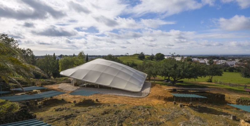 Elevated view of the textile canopy over the Postumio tombs with the necropolis archaeological remains and the Sevillian countryside in the background. Nd_Arquitectos. Spain. Photo by Jesús Granada.