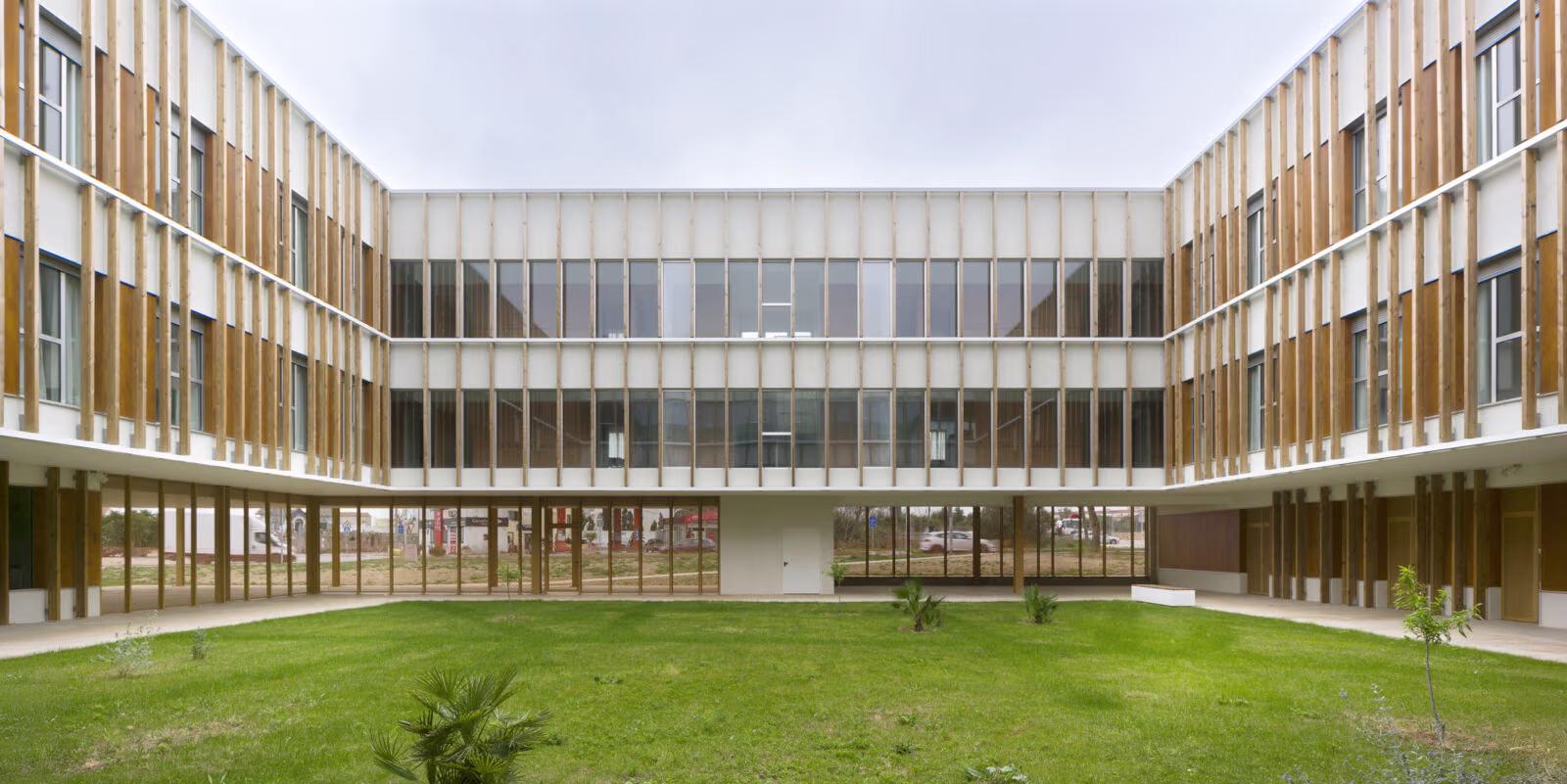Intermediate garden between modules, sheltered pedestrian route beneath the deep facade. Residence for the Elderly in Mahón, Menorca. Antonio González Liñán, SV60 Arquitectos. Photography by Jesús Granada