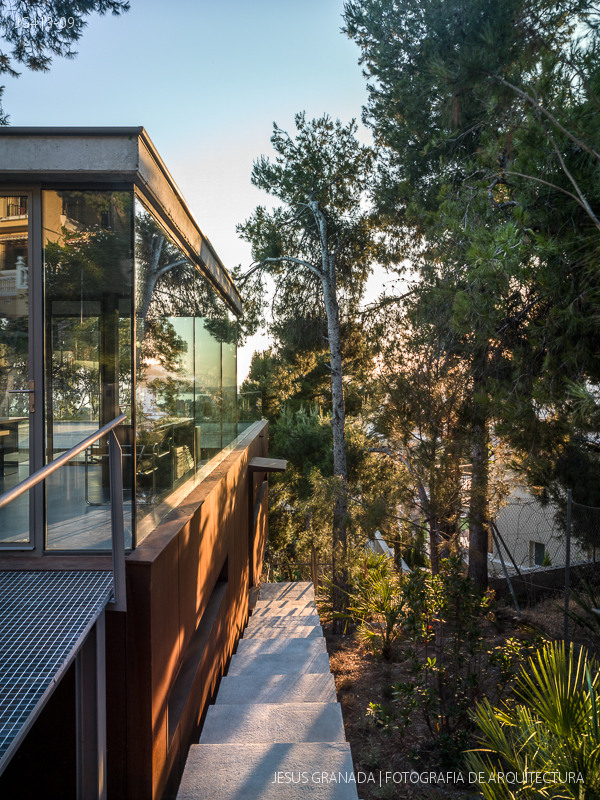 Casa en el monte, fachada oeste al atardecer entre pinos mediterráneos. Vivienda bioclimática experimental de Rafael de Lacour en El Candado, Málaga. Fotografía de Jesús Granada.