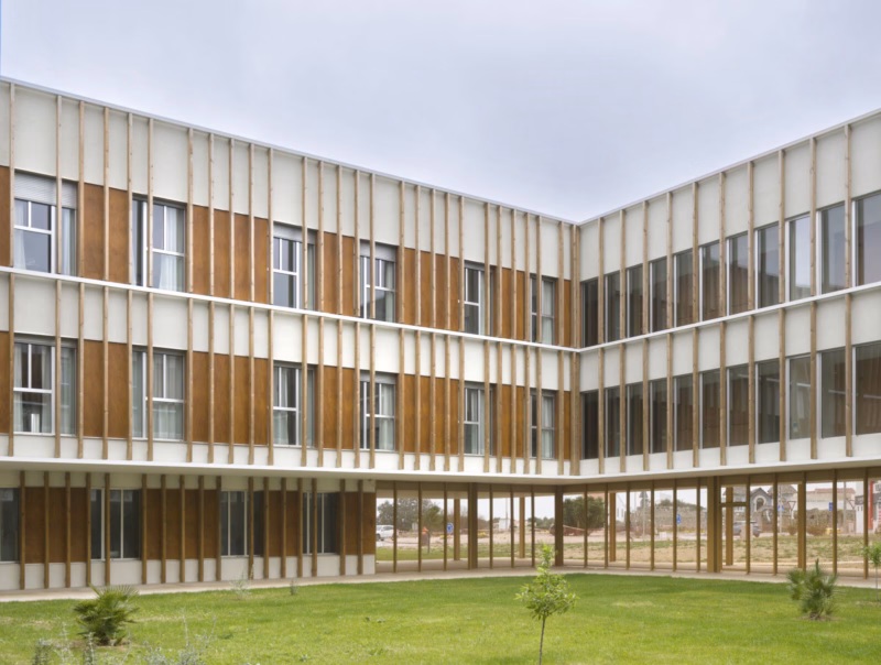 Fachada principal de la residencia con envolvente de lamas de madera y hormigón. Residencia personas dependientes en Mahón, Menorca. Antonio González Liñán, SV60 Arquitectos. Fotografía de Jesús Granada