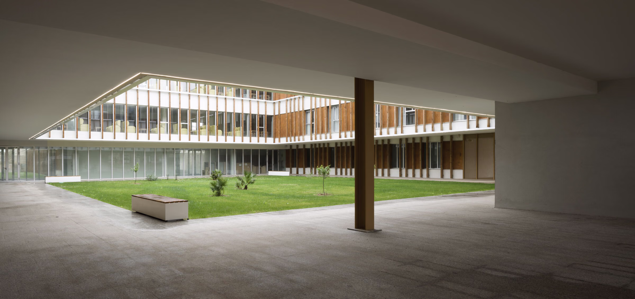 Uno de los tres jardines que articulan la planta, vegetación y pavimento bajo la estructura. Residencia personas dependientes en Mahón, Menorca. Antonio González Liñán, SV60 Arquitectos. Fotografía de Jesús Granada